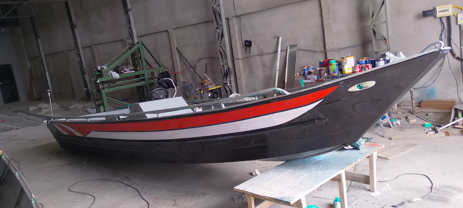 Lancha em pintura final — vermelho e preto